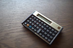 Imagem de uma calculadora HP 12c, indicando que o tema pode ser complexo, mas é permitido usar uma
