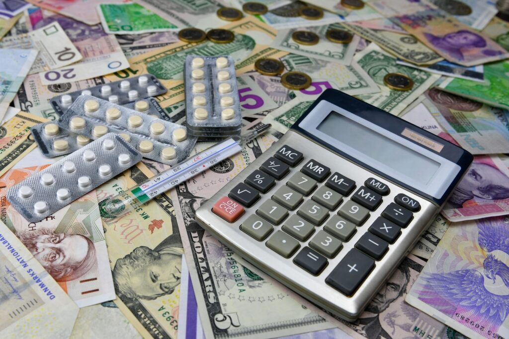 Uma calculadora sobre múltiplas cédulas de dinheiro representando a necessidade de uma reserva de emergência