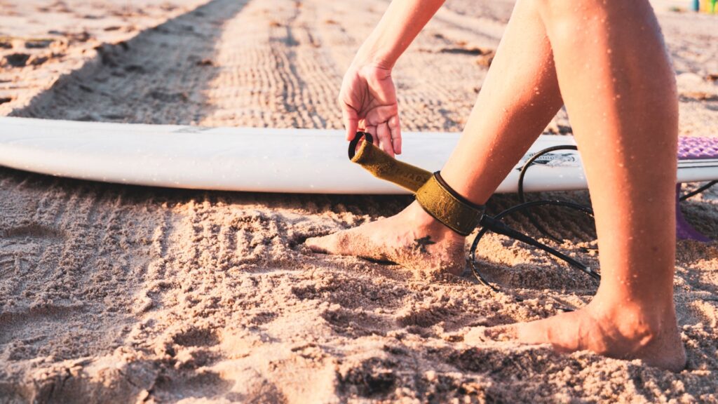 Surfista prendendo a prancha na própria perna