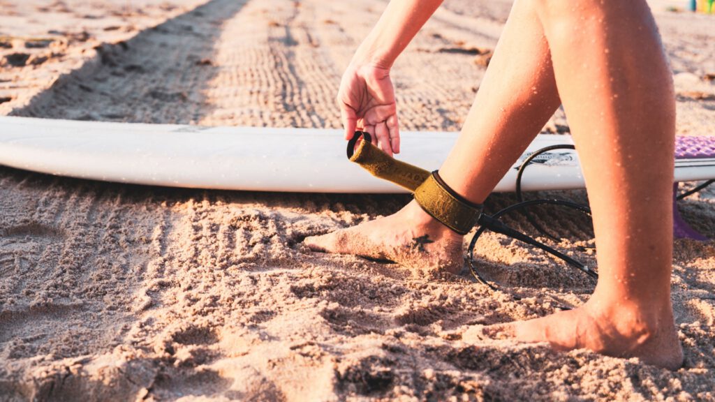 Surfista prendendo a prancha na própria perna
