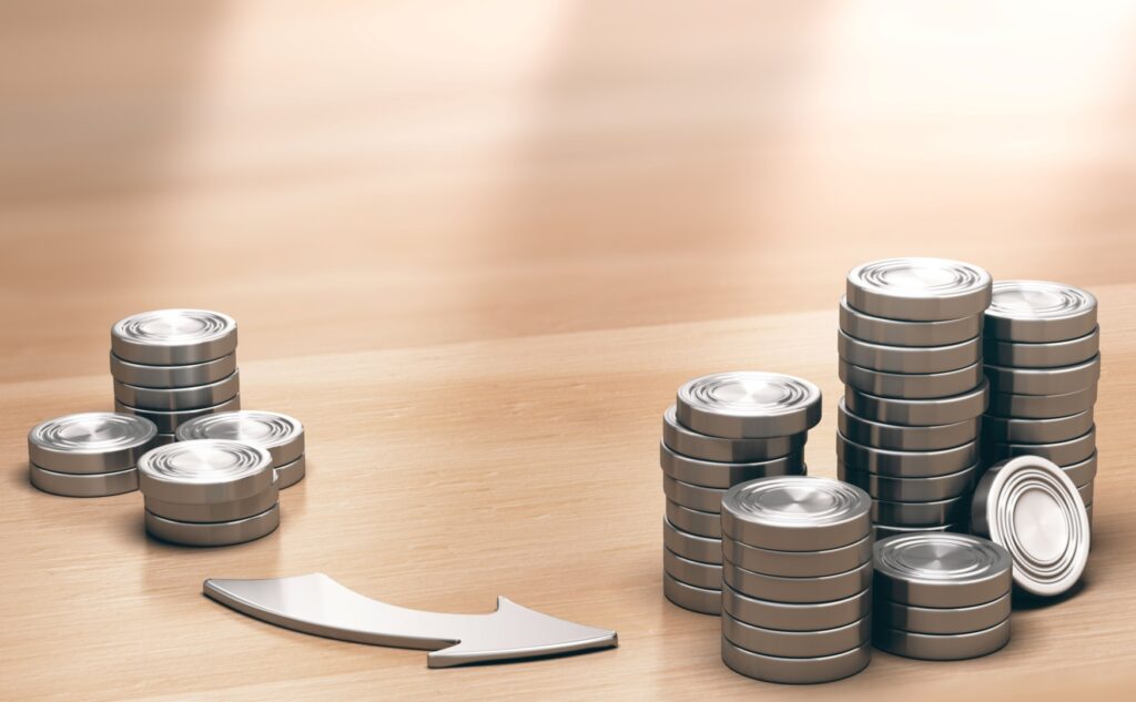 Duas pilhas de moedas com uma seta apontando de uma pilha para outra indicando a possibilidade de reinvestimento