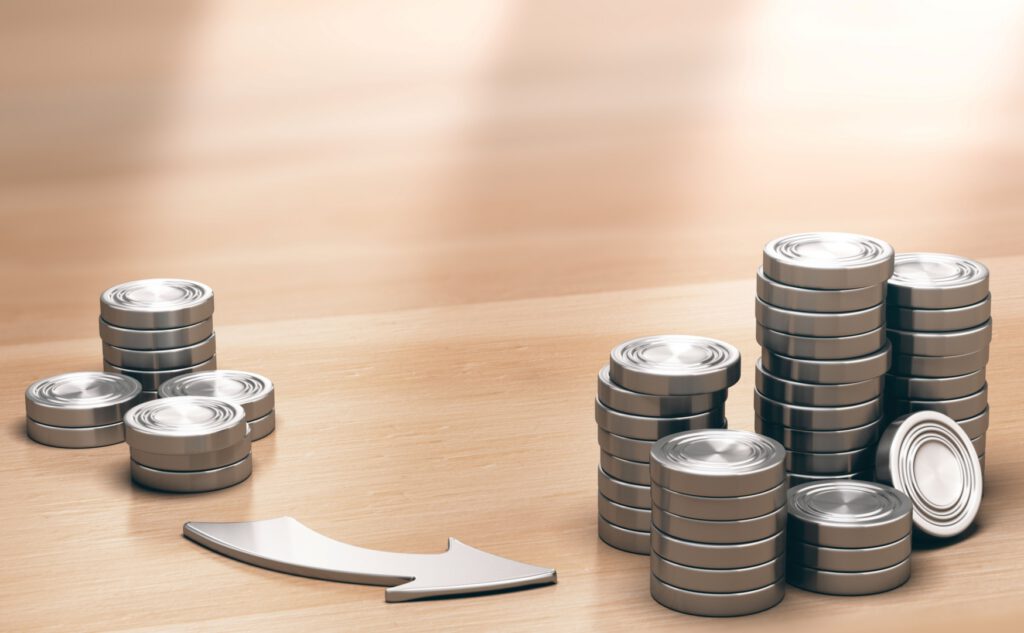 Duas pilhas de moedas com uma seta apontando de uma pilha para outra indicando a possibilidade de reinvestimento