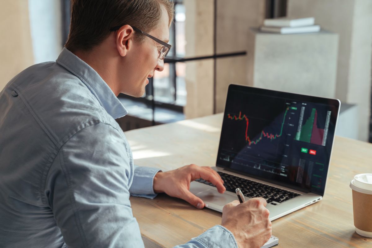Analista financeiro fazendo anotações analisando o mercado