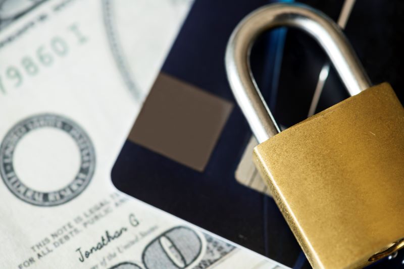 Um cadeado sobre documentos e cartão de crédito mostrando a segurança do setor financeiro 