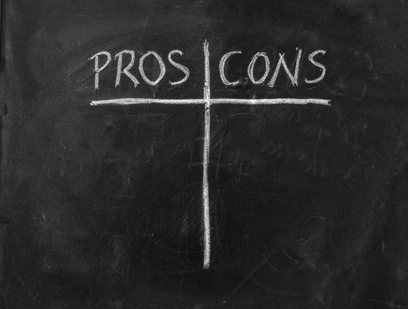 Quadro negro com as palavras Pros (Prós) e Cons (Contras) indicando os prós e contras de se investir em debêntures e notas promissórias