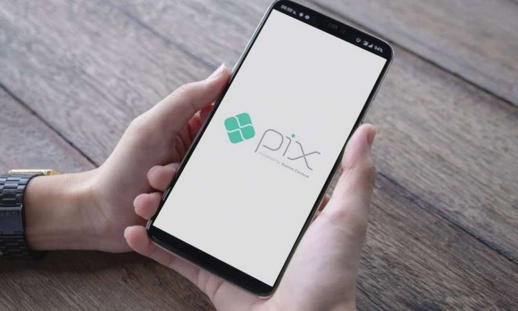 Mãos segurando um celular com símbolo do Pix, representando como o pix funciona