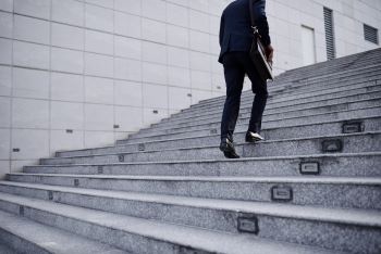 Homem subindo escadaria, representando primeiros passos na declaração de fundos imobiliários