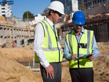 Homens em uma construção, representando FIIs de tijolo