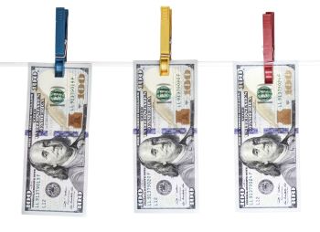 cédulas de dólar penduradas em um varal, representando lavagem de dinheiro